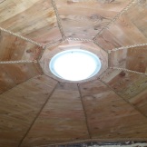 Interior roof ceiling finish of the eco-hut complete with circular tube light, recycled ship lap, and jute rope for trim.